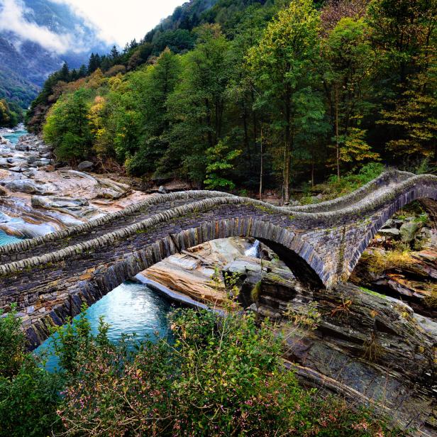 Die mittelalterliche Steinbrücke Ponte dei Salti überspannt den türkisfarbenen Fluss Verzasca.
