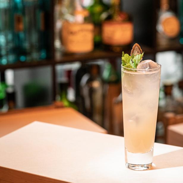 Ein erfrischender Cocktail mit Eis und Minze auf einer Bar steht bereit.