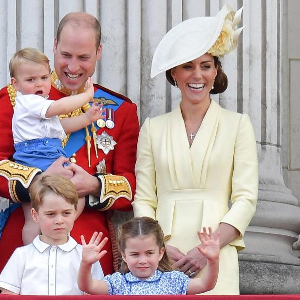 Prinz William und Prinzessin Kate mit ihren Kindern auf einem Balkon winkend.