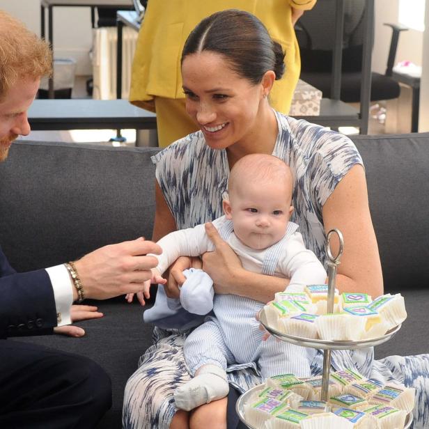 Harry, Meghan und Archie sitzen zusammen auf einem Sofa.