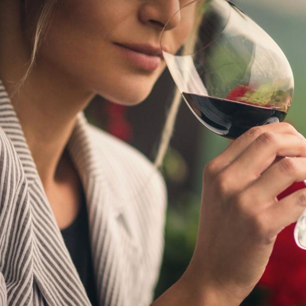 Frau trinkt Rotwein.