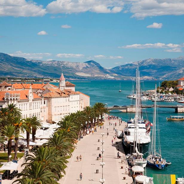 Die Hafenpromenade von Trogir mit Blick auf das Meer und die Berge.