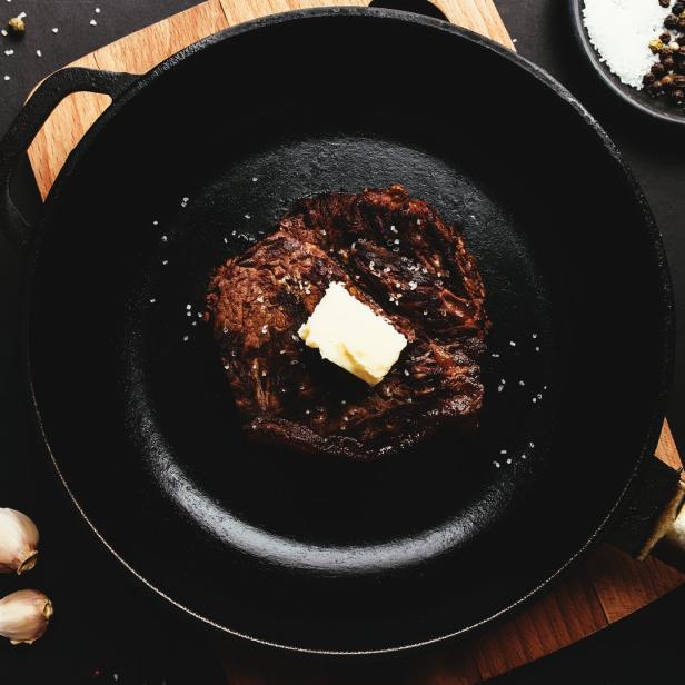 Ein Steak mit einem Stück Butter in einer gusseisernen Pfanne.