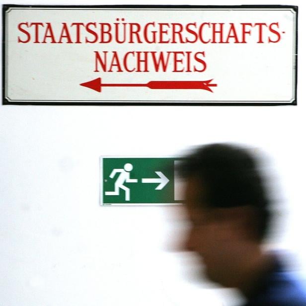 Ein Schild mit der Aufschrift „Staatsbürgerschaftsnachweis“ und ein grünes Notausgangsschild.