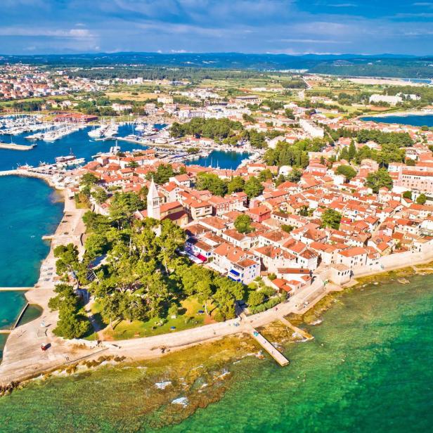 Eine Luftaufnahme von Novigrad, einer Stadt mit rotem Dach am Meer.