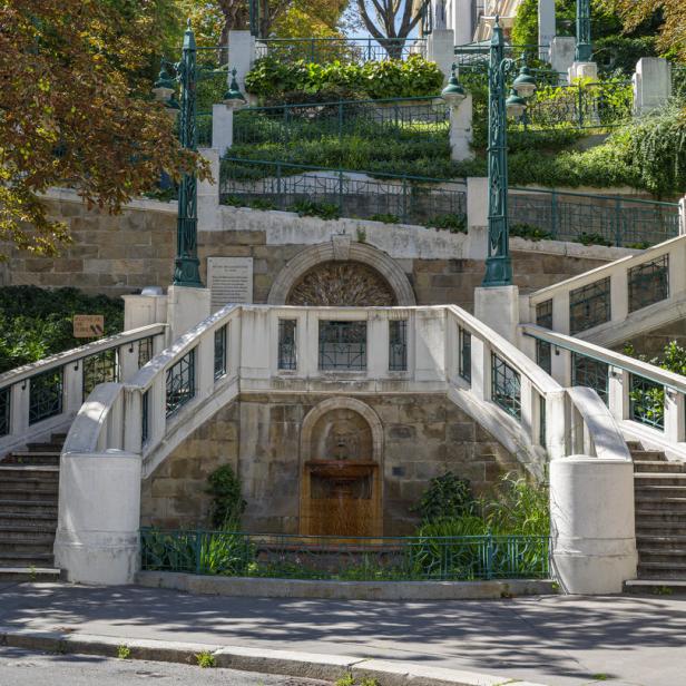 Die Wotrubakirche in Wien, umgeben von Bäumen und Treppen.