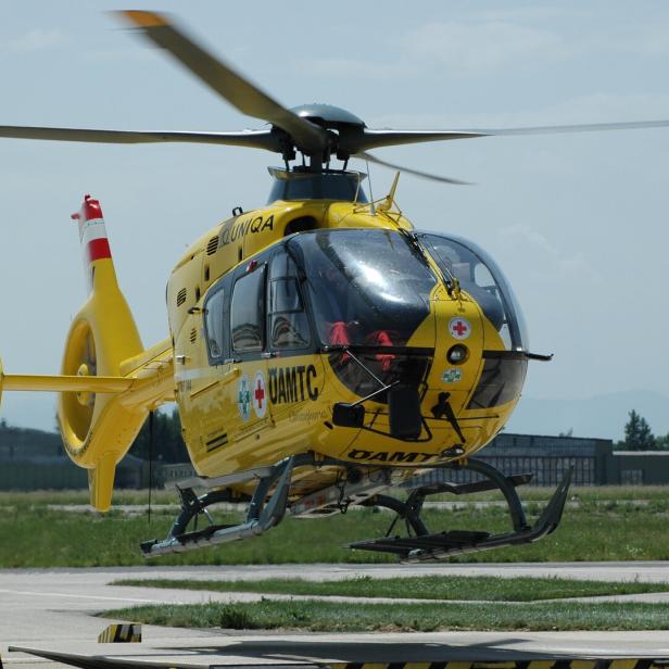 Ein gelber Rettungshubschrauber des ÖAMTC steht auf einem Flugfeld.