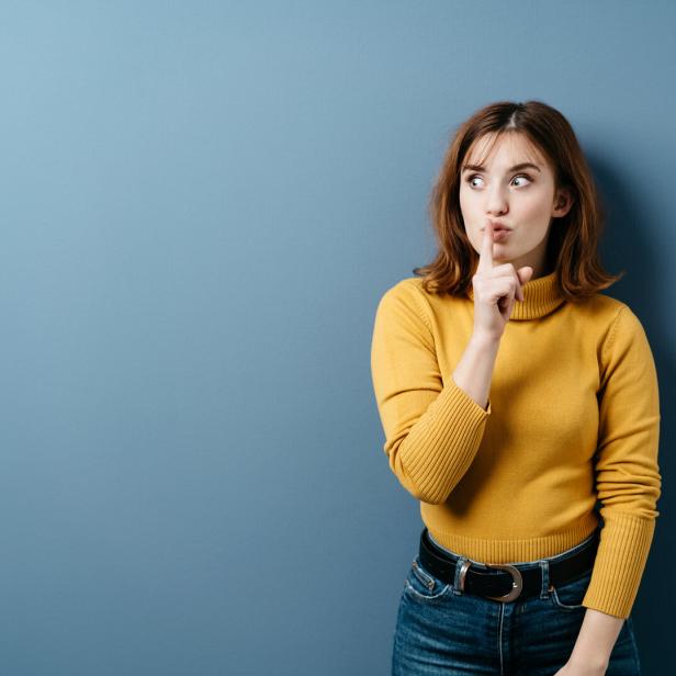 Young woman making a shushing gesture