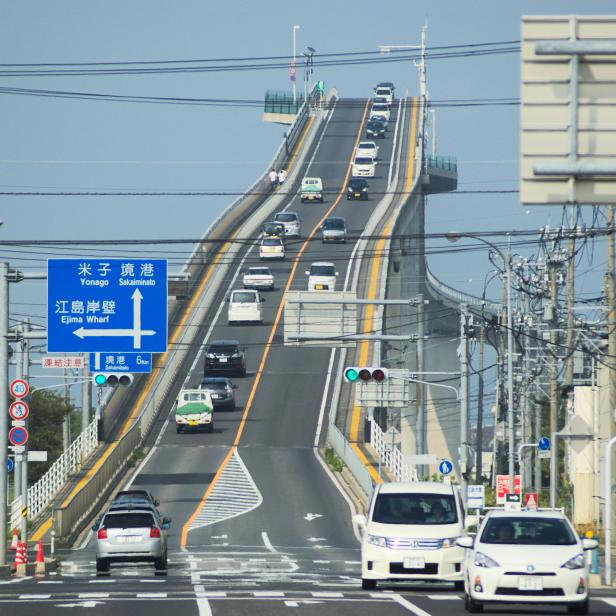 Die Eshima Ohashi Brücke, eine steile Betonbrücke in Japan, mit regem Autoverkehr.