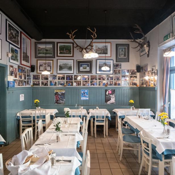 Ein einladendes Restaurant mit gedeckten Tischen und dekorativen Bildern an den Wänden.