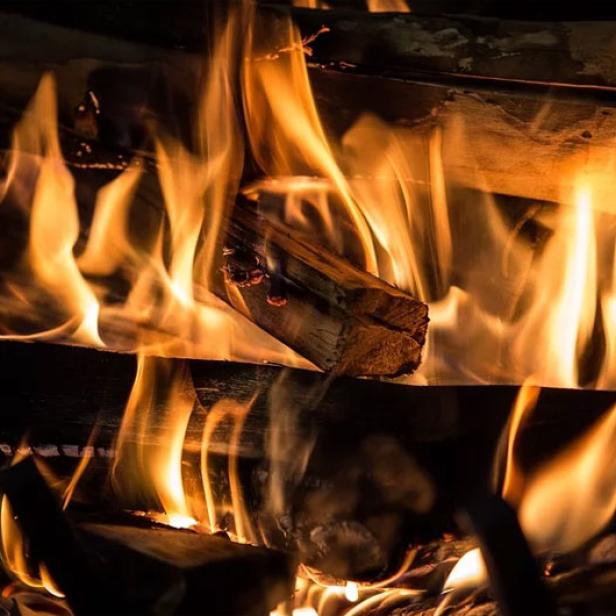 Ein Kaminfeuer brennt mit hellen Flammen.
