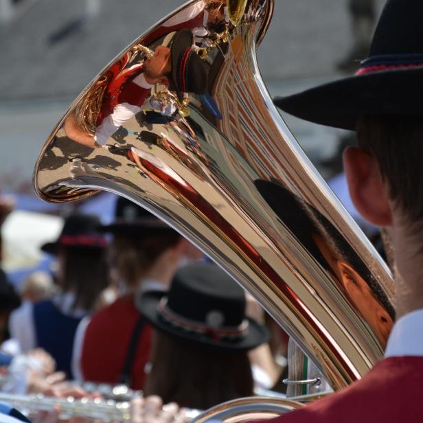 Ein Musiker mit Tracht spielt auf einem glänzenden Baritonhorn.
