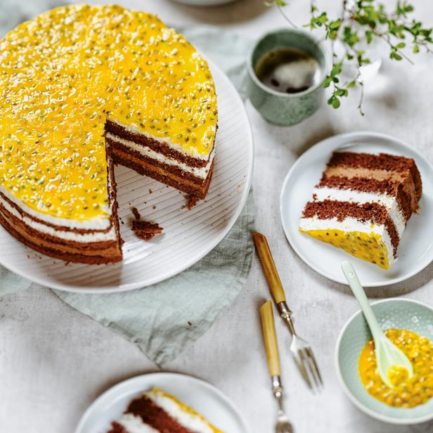 Ein Schokoladenkuchen mit Maracuja-Guss steht auf einem Tisch.