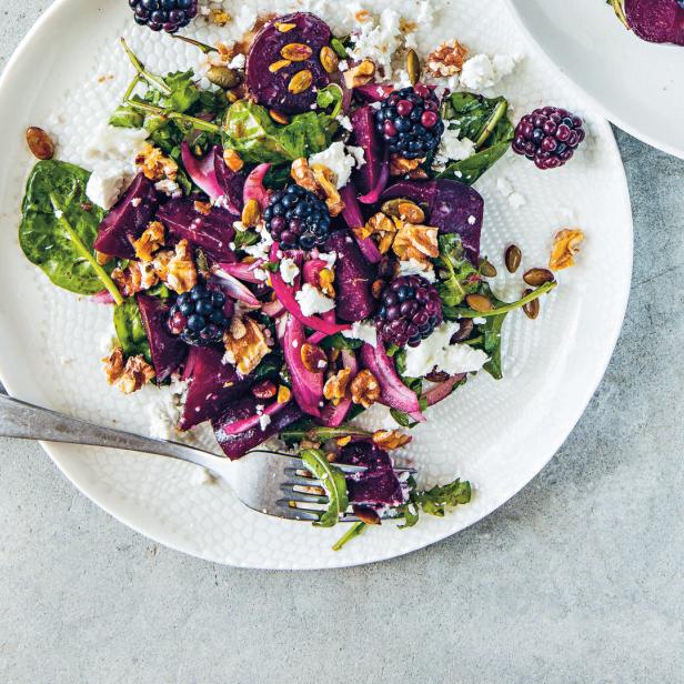 Ein Teller mit einem Salat aus Rote Bete, Brombeeren, Ziegenkäse und Walnüssen.