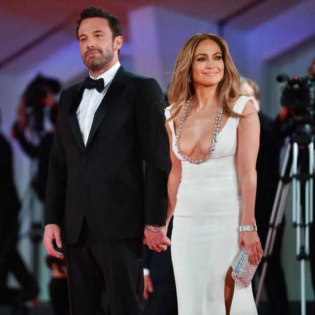 Ben Affleck und Jennifer Lopez halten Händchen auf einem roten Teppich.