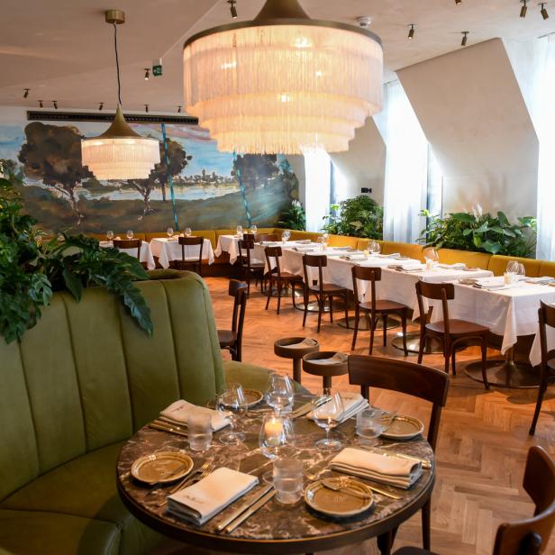Ein elegantes Restaurant mit gedeckten Tischen und üppiger Dekoration.