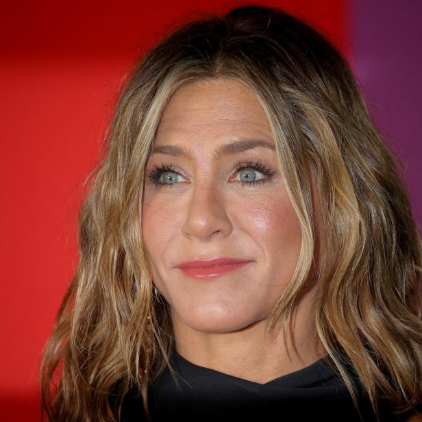 Ein Porträt von Jennifer Aniston mit blonden Haaren und blauen Augen.