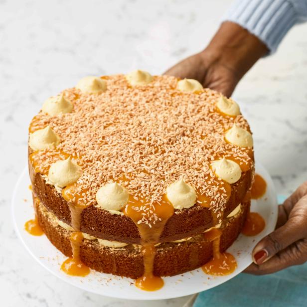 Ein zweistöckiger Kuchen mit Karamell, Kokosraspeln und Creme wird präsentiert.