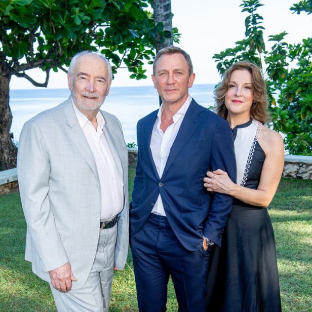 Daniel Craig posiert mit zwei anderen Personen im Freien.