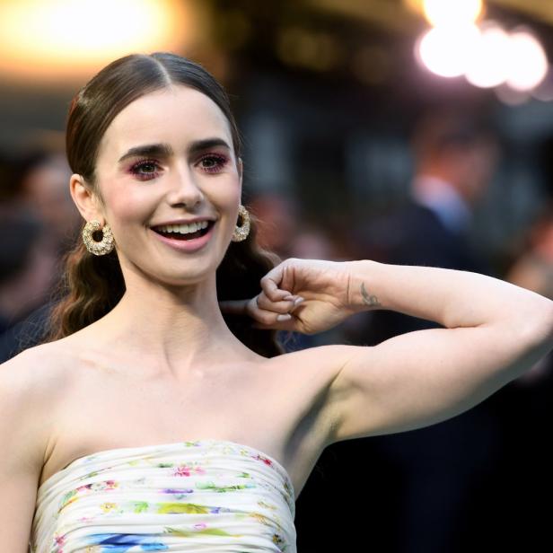 Lily Collins lächelt auf dem roten Teppich.