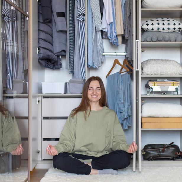 Junge Frau freut sich über einen ordentlichen Kleiderschrank (Symbolfoto).