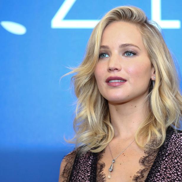 Jennifer Lawrence posiert vor einem blauen Hintergrund.
