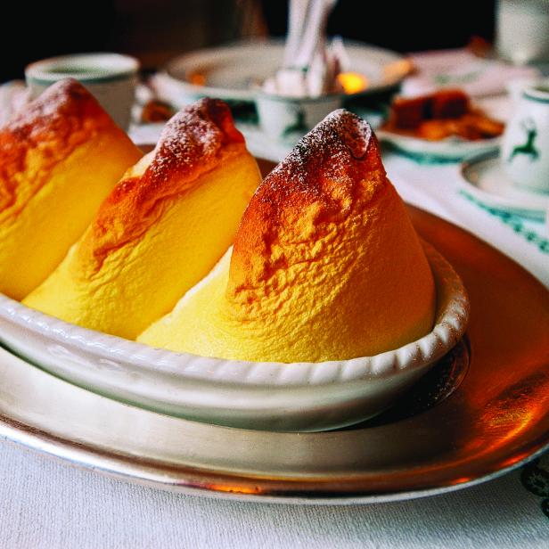 Drei Salzburger Nockerl auf einem Teller, bestäubt mit Puderzucker.