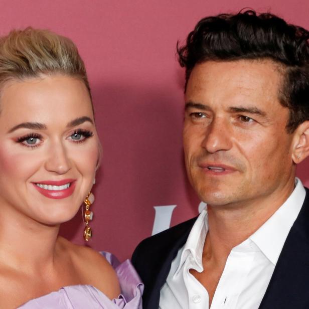 Katy Perry und Orlando Bloom posieren zusammen auf einem roten Teppich.