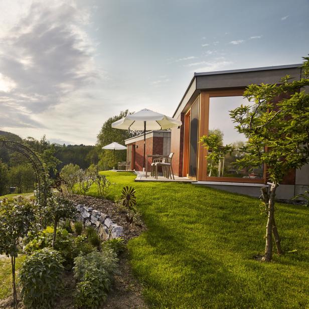 Ein Garten führt zu einem modernen Haus mit Terrasse und Blick auf die Landschaft.