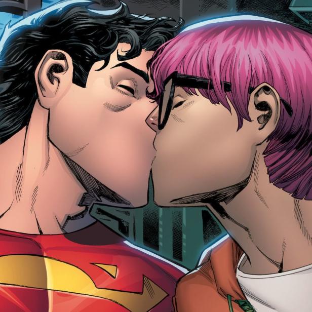 Superman küsst einen Mann mit pinken Haaren vor einem Fenster.