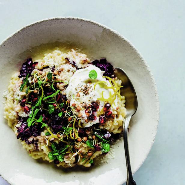 Ein Teller Risotto mit Radicchio, Granatapfelkernen, Kräutern und einem Klecks Creme fraîche.