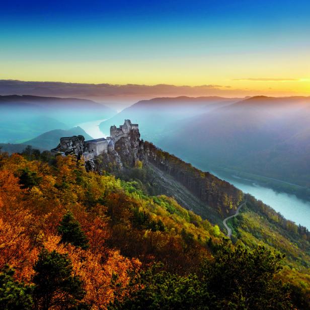 Die Burgruine Dürnstein thront über der Donau im herbstlichen Sonnenlicht.