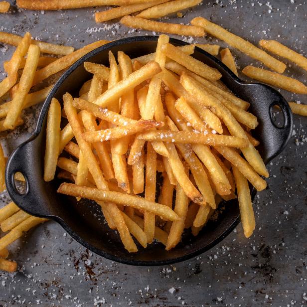 Eine Schale voller goldgelber, gesalzener Pommes Frites.