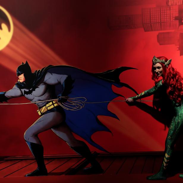 Batman und Poison Ivy ziehen an einem Seil vor dem Hintergrund von Gotham City auf der CCXP Comic Con.