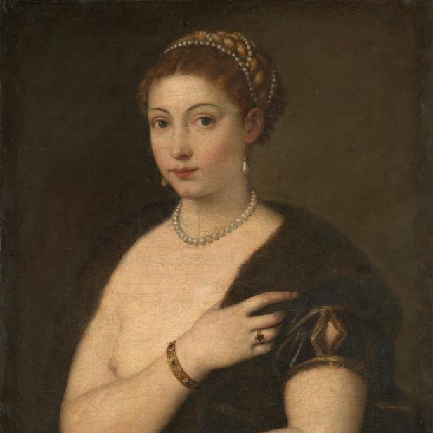 Ein Porträt einer jungen Frau mit Perlenkette und dunklem Umhang.