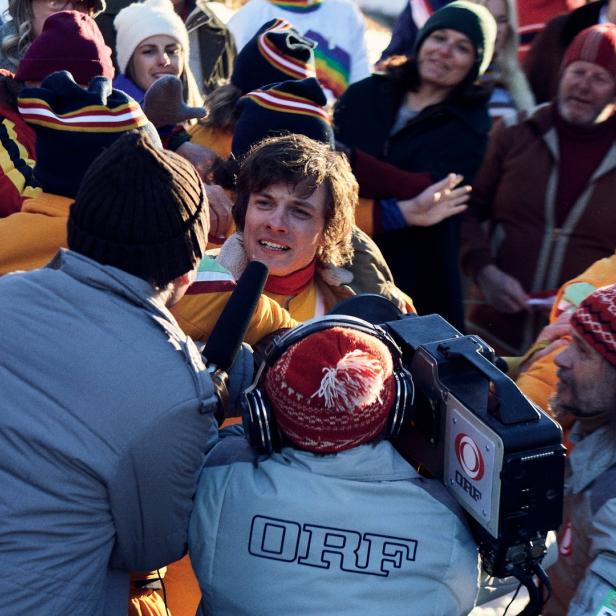 Ein Skifahrer wird von einem Kamerateam des ORF interviewt.