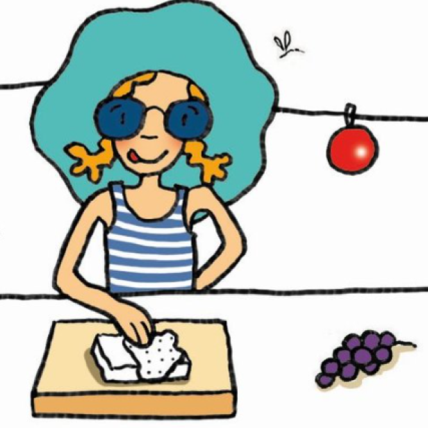 Eine blonde Frau mit Sonnenbrille und Hut bereitet ein Sandwich zu.
