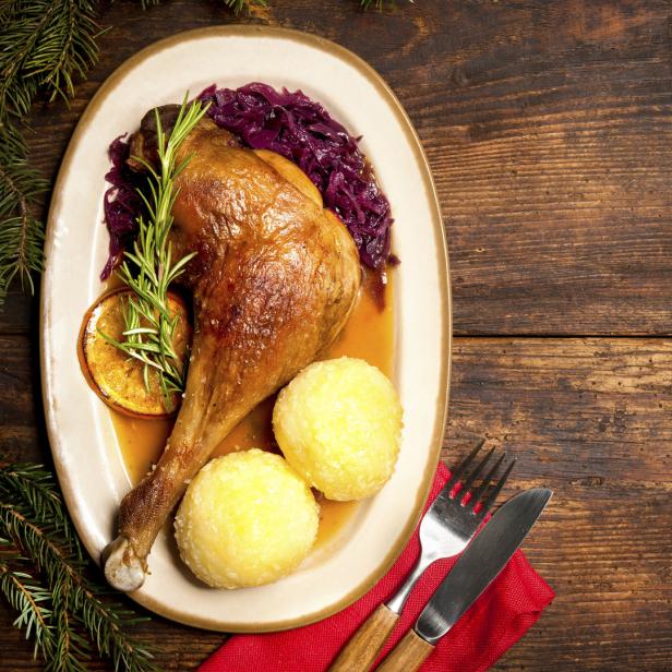 Ein Teller mit knuspriger Gänsekeule, Rotkohl und Kartoffelknödeln.