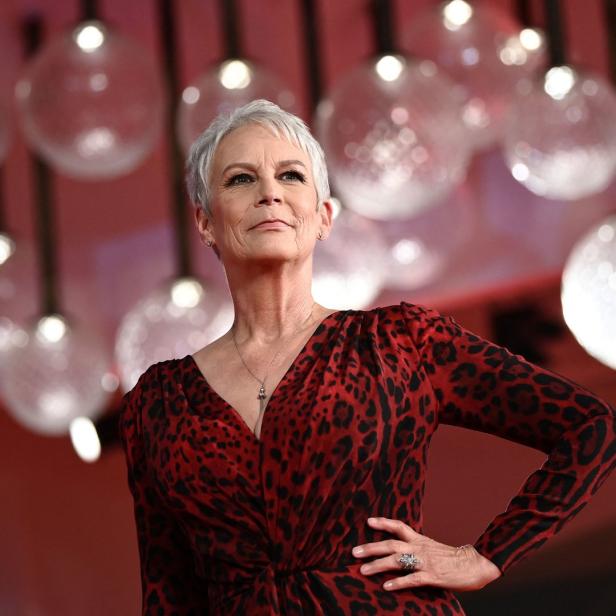 Jamie Lee Curtis posiert in einem roten Kleid mit Leopardenmuster.