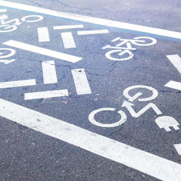 Auf der Straße sind Symbole für Fahrräder und E-Bikes aufgemalt.