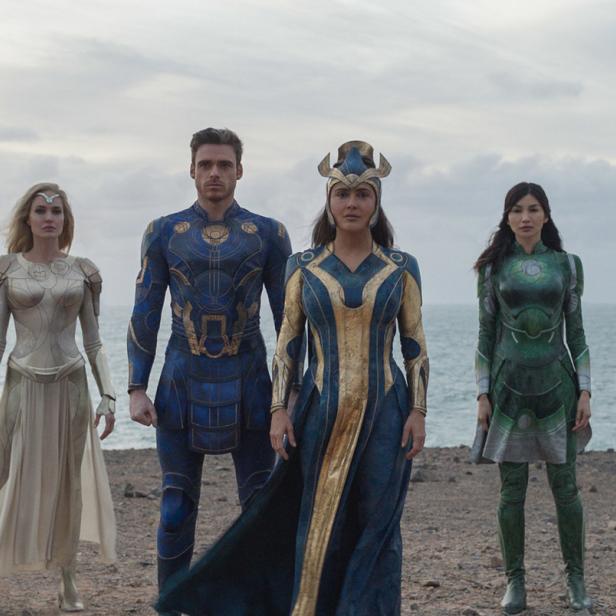 Die Gruppe der Eternals steht am Strand vor dem Meer.