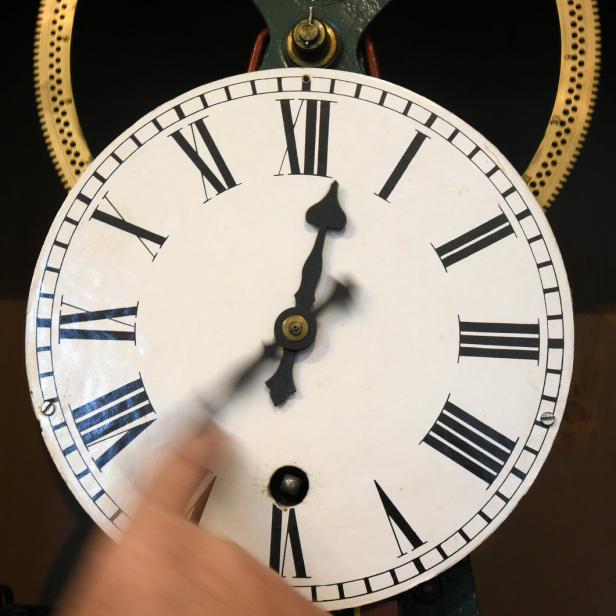 Eine Uhr mit römischen Ziffern zeigt fünf Uhr.
