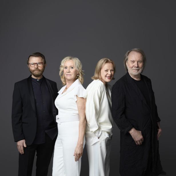 Die schwedische Popgruppe ABBA steht vor einem grauen Hintergrund.