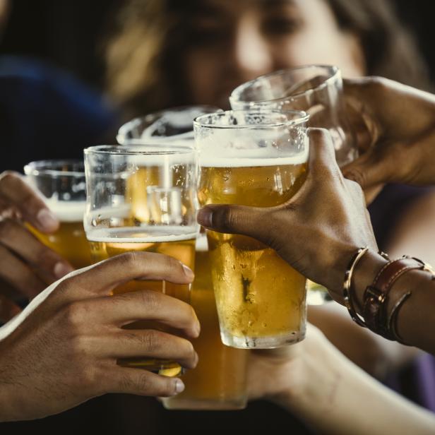 Eine Gruppe von Freunden stößt mit Biergläsern an.