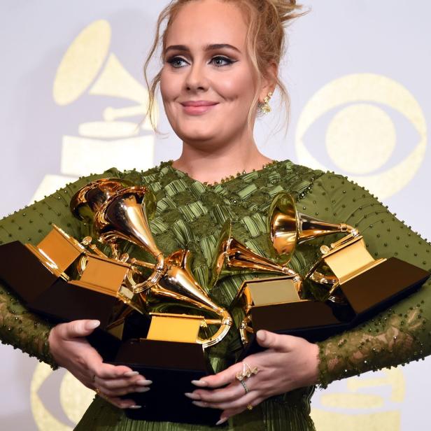 Adele hält mehrere Grammy Awards in ihren Armen.