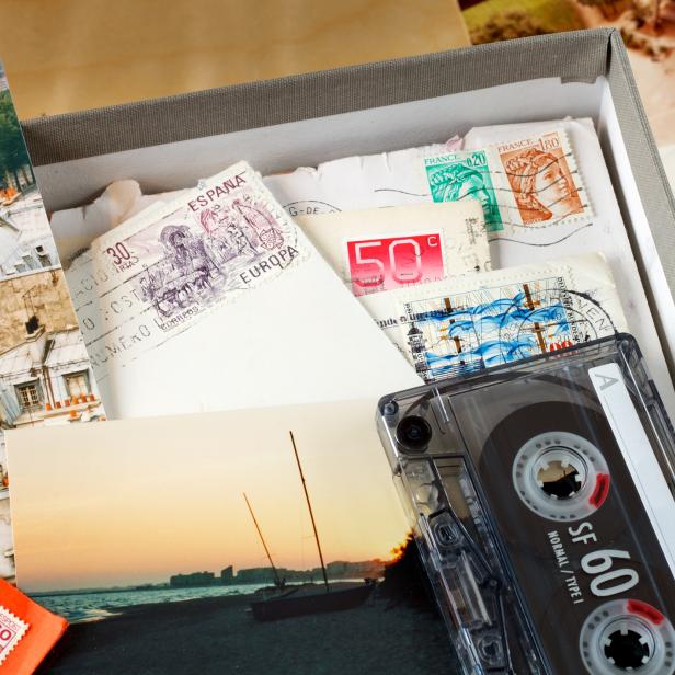 Eine Kassette und eine Schachtel voller alter Fotos und Briefmarken.