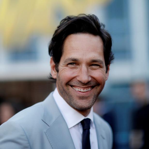 Ein lächelnder Paul Rudd in einem hellgrauen Anzug und dunkler Krawatte.