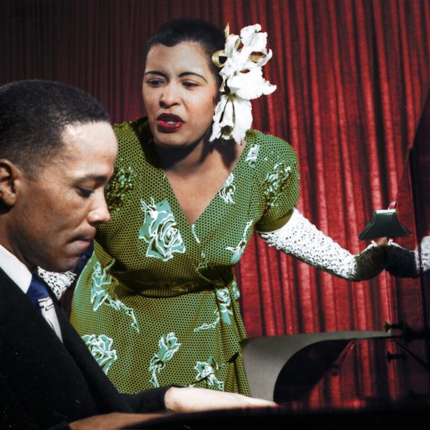 Billie Holiday singt, während ein Pianist sie begleitet.