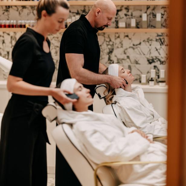 Zwei Kundinnen erhalten Gesichtsbehandlungen in einem Spa.