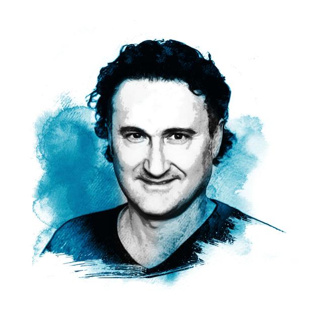 Ein Porträt eines Mannes mit dunklen, lockigen Haaren vor einem blauen Hintergrund.